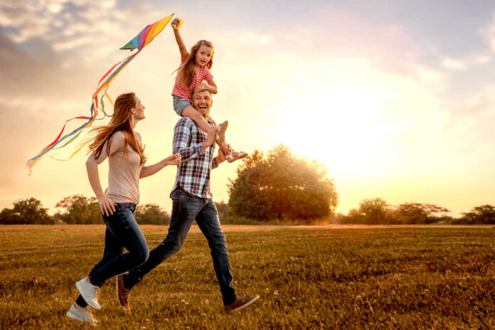 Family,Running,Through,Field,Letting,Kite,Fly