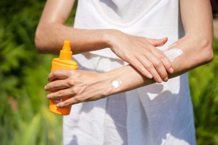 A,Young,Girl,In,A,White,Summer,Dress,Applies,Sunscreen