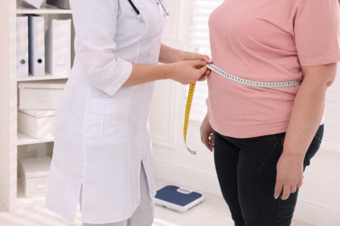 Nutritionist,Measuring,Overweight,Woman's,Waist,With,Tape,In,Clinic,,Closeup